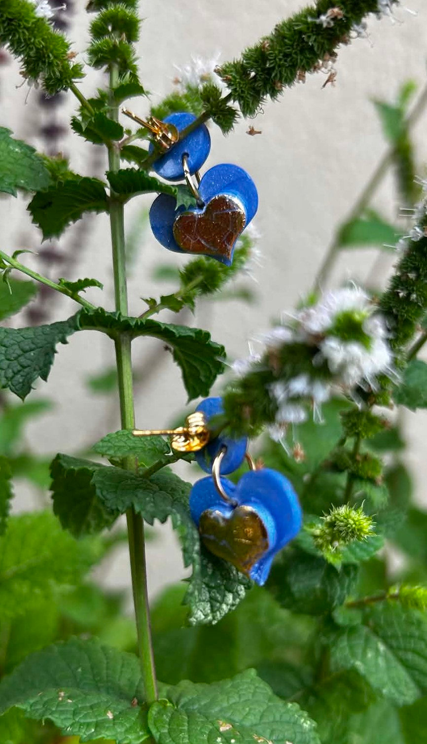 Détail des boucles d’oreilles cœurs bleues et dorées artisanales